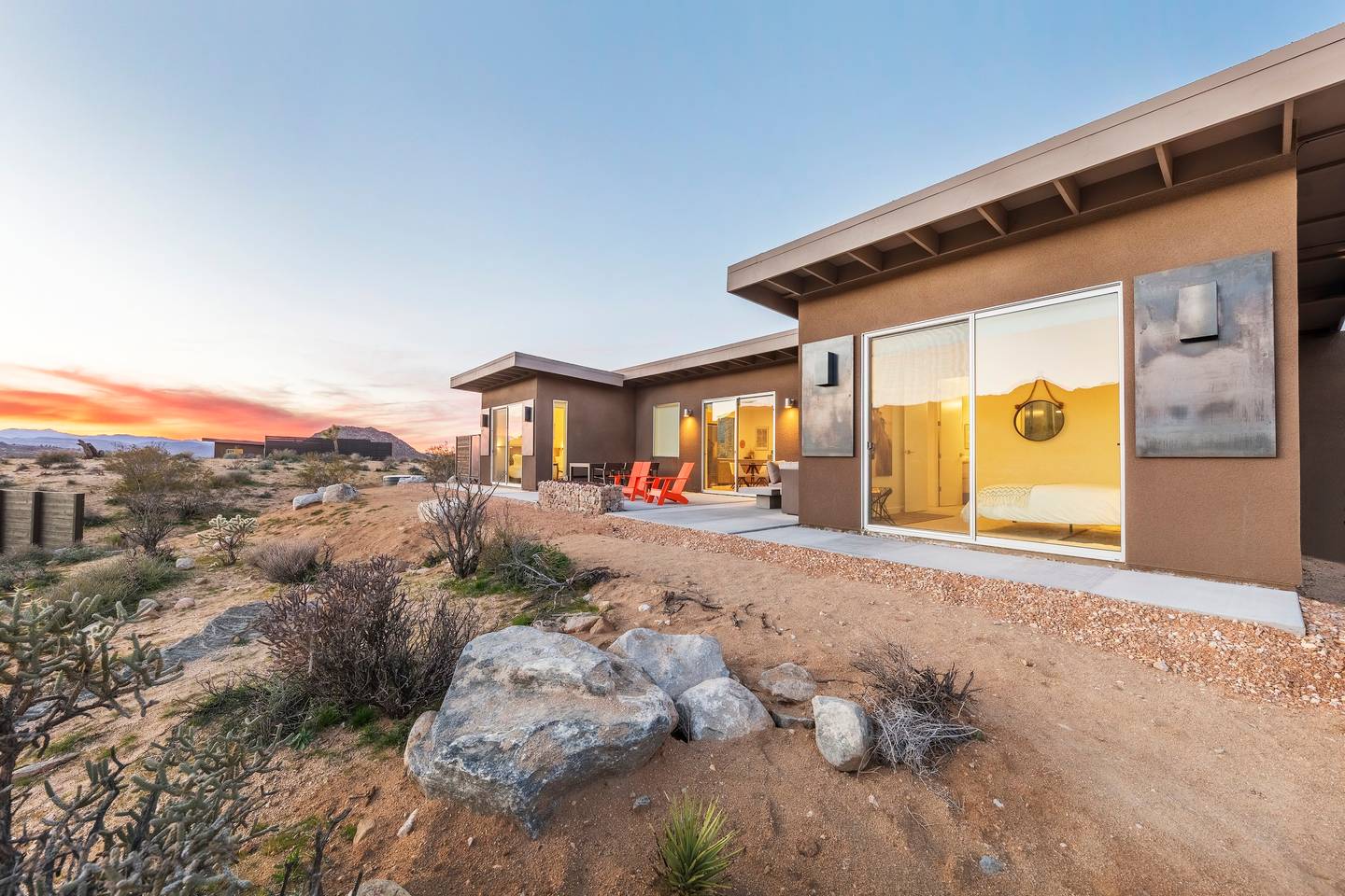 Desert home at sunset with modern design and outdoor seating.